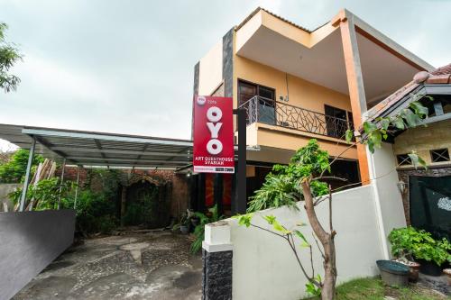 una casa con un cartel delante de ella en Super OYO 2285 Art Guest House Syariah, en Yogyakarta