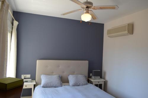 ein blaues Schlafzimmer mit einem Bett und einem Deckenventilator in der Unterkunft Vista Xalo in Alcalalí