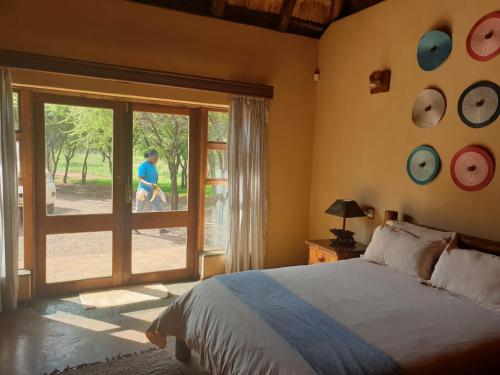 a bedroom with a bed and a sliding glass door at Makhato Bush Lodge 17 in Bela-Bela