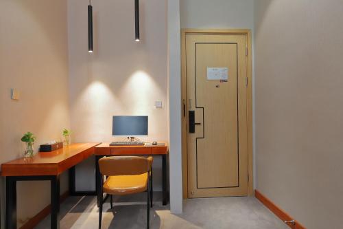 a room with a desk with a computer and a chair at Shanghai Menglong Hotel Management in Shanghai