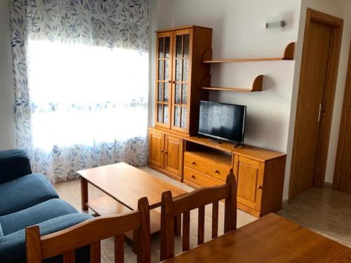 a living room with a couch and a tv and a table at Apartamentos En Deltebre in Deltebre