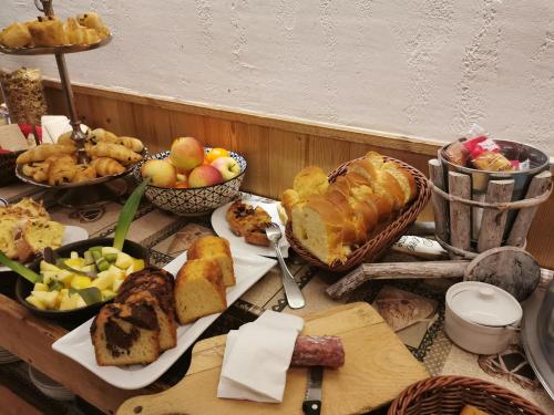 a table topped with lots of different types of food at Hôtel Du Midi in Thônes