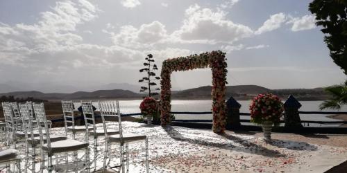 a wedding ceremony with chairs and a arch with flowers at Rive Du Lac in Lalla Takerkoust