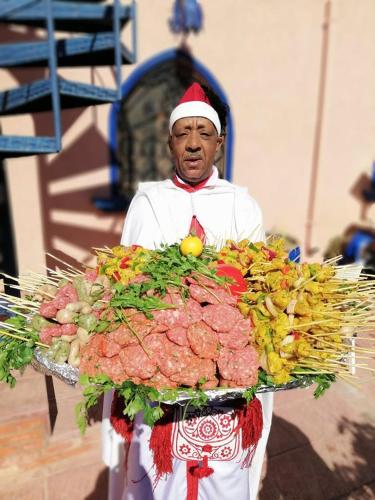 a man is holding a tray of food at Rive Du Lac in Lalla Takerkoust