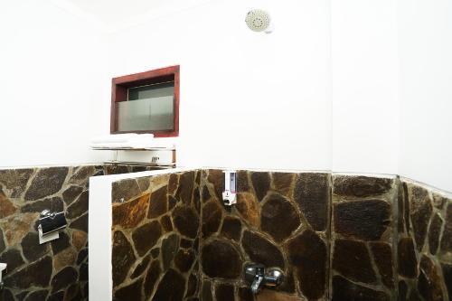 a bathroom with a stone shower with a window at Defada Village Bromo at Desa Wisata Bromo Mitra RedDoorz in Bromo