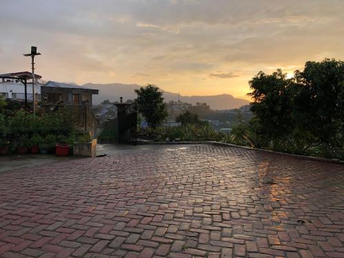 a brick driveway with a sunset in the background at Akim Homestay in Kohīma