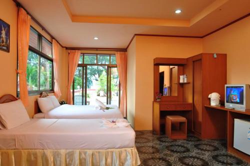 Cette chambre comprend deux lits et une télévision. dans l'établissement Island View Bungalows, à Choeng Mon Beach