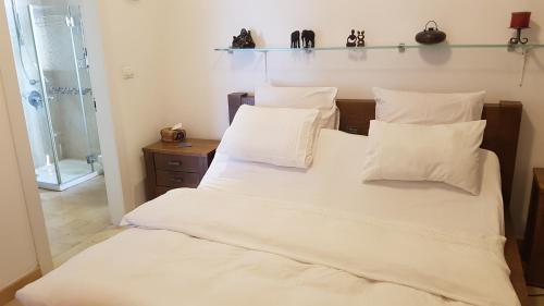 a bedroom with a bed with white sheets and pillows at Jaffa Family Penthouse, sea front , 3BR, 2BA, in Tel Aviv