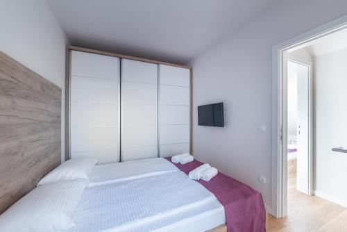 a bedroom with a large white bed with two towels at Vip Casa Club Zlatibor in Zlatibor