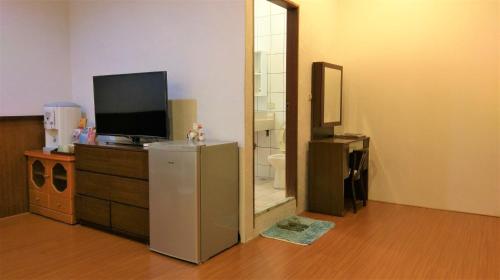 花蓮市的住宿－信義之家，一间房间,配有带镜子的梳妆台,电视