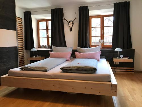 ein Schlafzimmer mit einem großen Bett mit rosa Kissen in der Unterkunft mein Quartier in Oberammergau