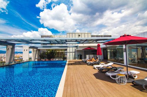 a pool on top of a building with chairs and umbrellas at D'majestic Place by Homes Asian 04 in Kuala Lumpur