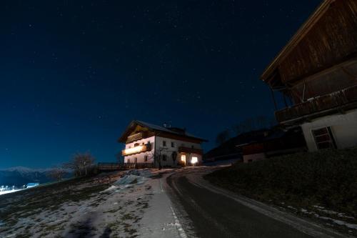 a house on the side of a dirt road at night at Huberhof Morgensonne in Terento
