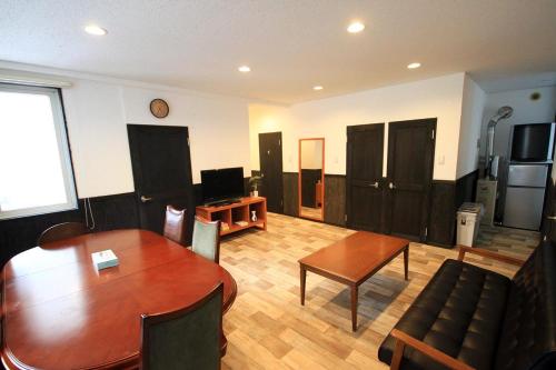 a living room with a wooden table and a couch at kODATEL コダテル 札幌大通公園 201 in Sapporo