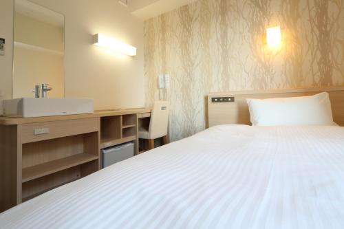 a hotel room with a bed and a sink at AB Hotel Yukuhashi in Yukuhashi