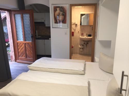 ザンクト・マルティンにあるChalet Raabeのベッド2台とバスルームへのドアが備わる客室です。