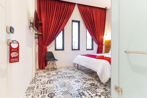 a bedroom with a bed and a red curtain at RedDoorz Plus At Mitrotel Medan in Sunggal
