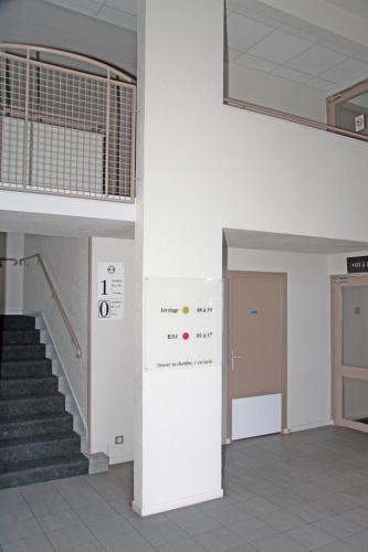 an empty lobby with stairs and a door at Hotel Inn design Vierzon in Vierzon