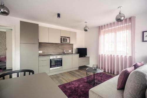 a kitchen and living room with a couch and a table at Apartments Villa Tatiana in Bled
