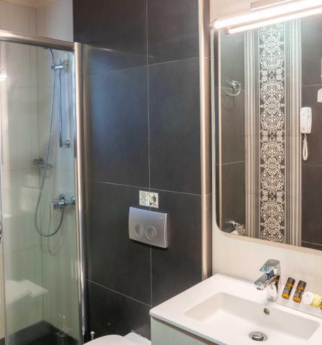 a bathroom with a shower and a sink and a toilet at Olympus Terra Boutique Hotel in Larisa