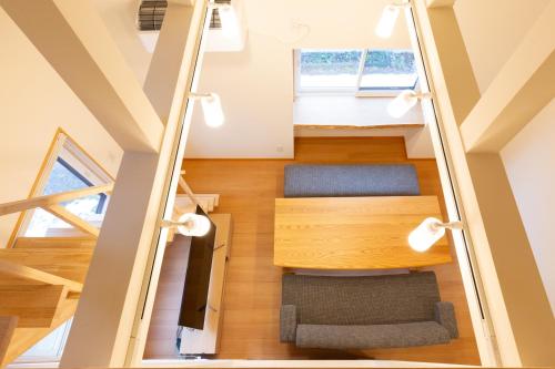 - une mezzanine avec un escalier et un canapé dans l'établissement 白馬パウダーマウンテン, à Hakuba