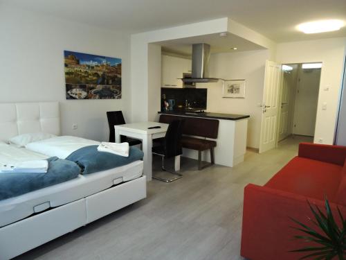 ein Schlafzimmer mit einem Bett und einem Schreibtisch sowie eine Küche in der Unterkunft 203 Rom, Studio Apartment, 38m2 1-4 Pers in Klagenfurt am Wörthersee