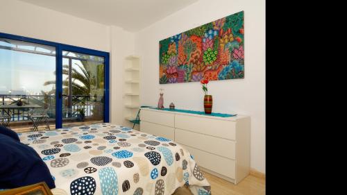 a bedroom with a bed and a painting on the wall at Apartment La Marina Sea Views with terrace By PVL in Arrecife