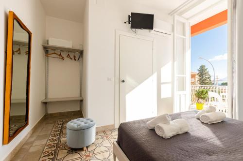 a bedroom with a bed and a large window at Villa Edera Rental Room in Santa Flavia