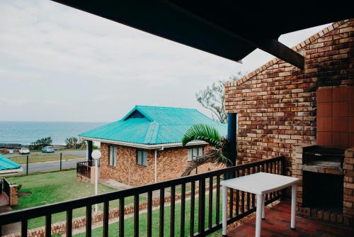 a balcony with a view of the ocean at Port Edward Holiday Resort in Port Edward