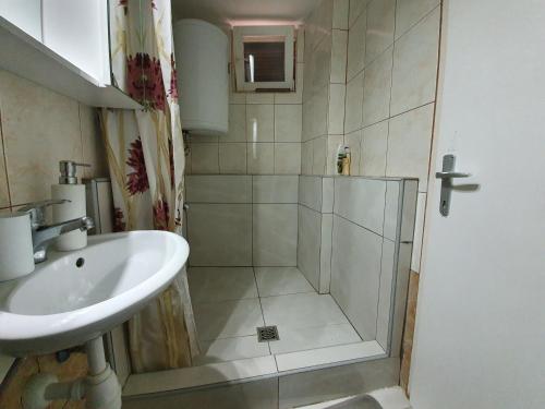 łazienka z prysznicem i umywalką w obiekcie Guest House Novalja w Novalji