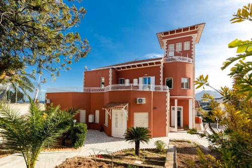 an image of a red house with palm trees at Villa Edera Rental Room in Santa Flavia