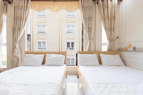 2 Betten in einem Zimmer mit 2 Fenstern in der Unterkunft MOTEL THỦY TIÊN in Vũng Tàu