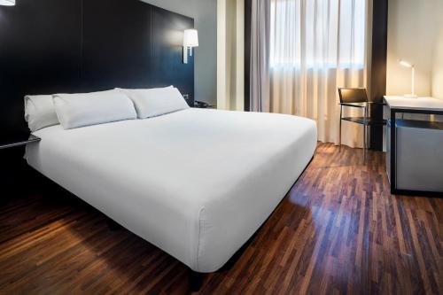 ヘタフェにあるB&B HOTEL Madrid Getafeのホテルルーム内の大きな白いベッド