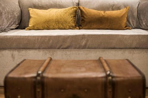 a brown suitcase sitting in front of a couch at Hotel Pok Garni in Brezovica