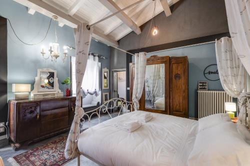 ein Schlafzimmer mit einem Himmelbett und einem Spiegel in der Unterkunft Rome As You Feel - Torre Design Apartment in Rom