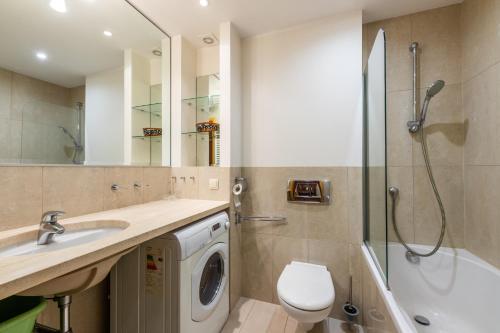 a bathroom with a washing machine and a shower at Glow Apartments, Apartament Meriwa Sopot in Sopot