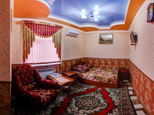 サラトフにあるHotel ARS (АРС)のベッド、ソファ、椅子が備わる客室です。