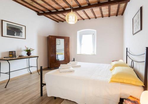ein Schlafzimmer mit einem großen weißen Bett mit gelben Kissen in der Unterkunft Appartamento Palma in Spello