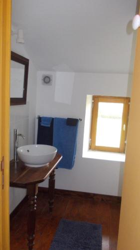 a bathroom with a white sink and a window at La Gaucherie aux Dames in Vihiers