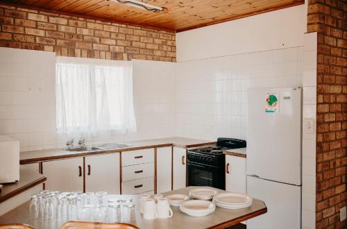 a kitchen with white appliances and a white refrigerator at Port Edward Holiday Resort in Port Edward