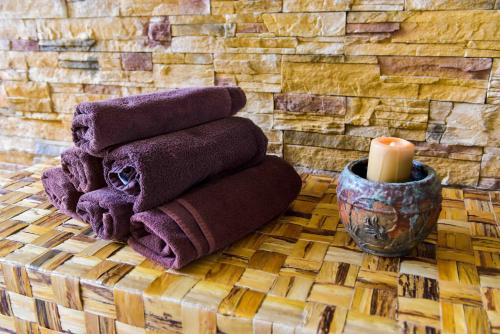 a pile of purple towels and a candle on a table at Hotel Bojur & Bojurland Apartment Complex in Bansko