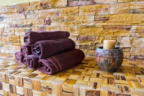 a pile of towels sitting on a table with a candle at Hotel Bojur & Bojurland Apartment Complex in Bansko