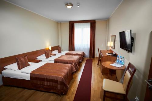 um quarto de hotel com duas camas e uma televisão em Centrum Okopowa 55 em Varósvia