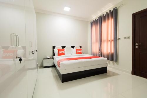 a white bedroom with a bed and a window at Super OYO 106 Muscat Grand Hotel Apartment in Seeb