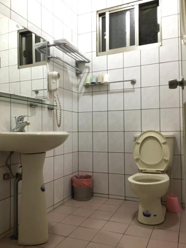 a bathroom with a toilet and a sink at Alishan MinYue Hotel in Fengshan