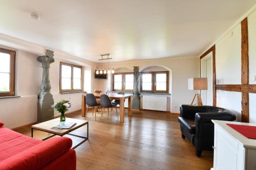 a living room with a red couch and a table at Hotel Montfort-Schlössle in Lindau