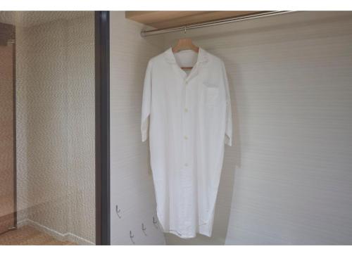 a white shirt is hanging in a closet at Sunshine City Prince Hotel Ikebukuro Tokyo in Tokyo