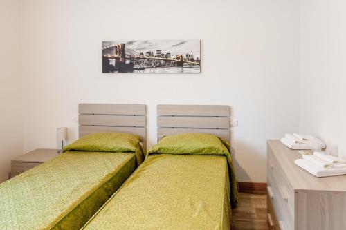 a bedroom with two twin beds and a desk at Appartamento Le Barche in Mestre