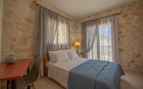 a bedroom with a bed and a desk and a window at Kantouni House in Volimes