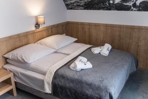 a bedroom with a bed with two towels on it at Pokoje u Nasyj Kasi in Poronin